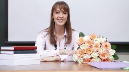 учитель с цветами за столом