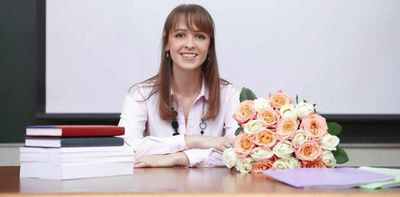 учитель с цветами за столом