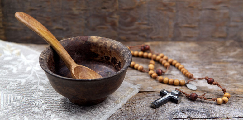 глиняная миска с деревяной ложкой и церковными четками