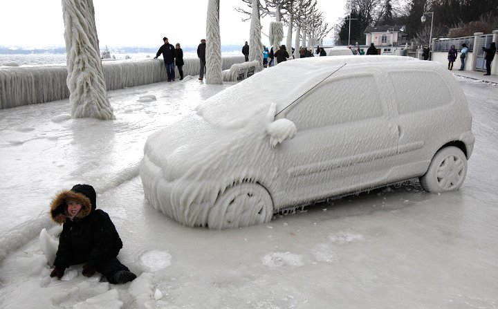 обледеневший автомобиль и деревья в снегу в городе